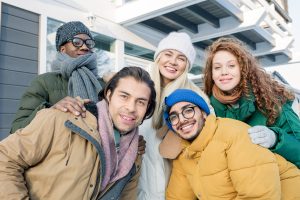 Five Multi-Ethnic Friends enjoying to learn Romanian clothing vocabulary, dressed in winter cloths
