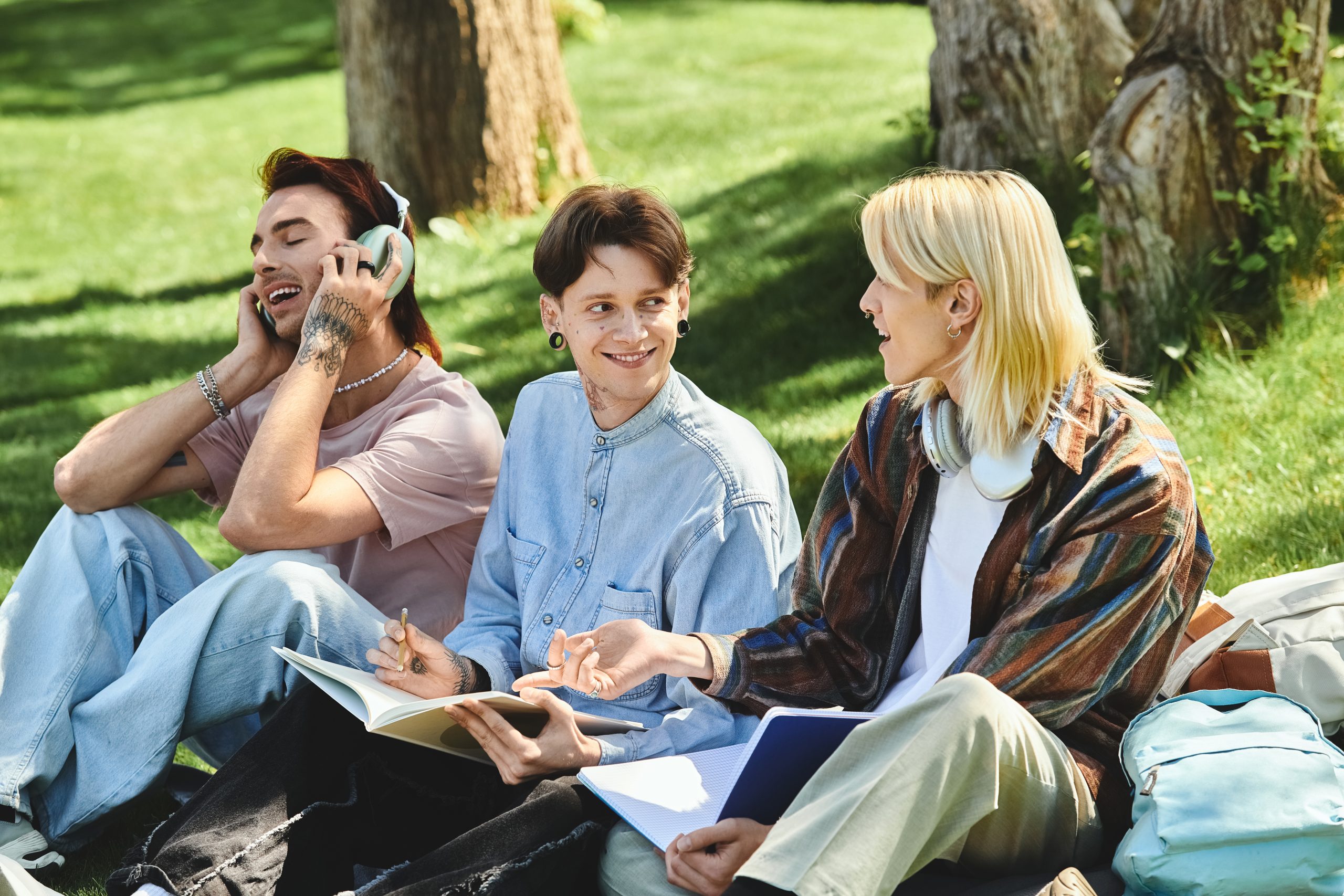 while sitting in a grassy park, the young friends casually dressed learn Romanian demonstratives and share a moment of laughter and conversation