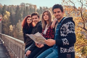 Young friends learn Romanian time vocabulary. They are planning a trip at autumn forest.