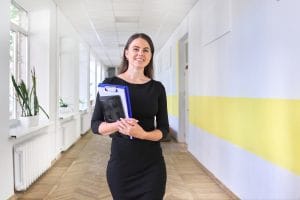 Young smiling female teacher has prepared herself to teach Romanian professions vocabulary
