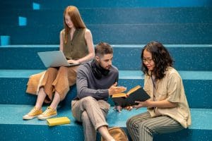 Romanian imperative explained by a confident student to female groupmate while pointing at page of book