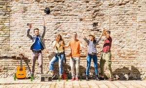 after learning A2 Romanian Lessons about feelings, a happy friends group having fun outdoor cheering with confetti