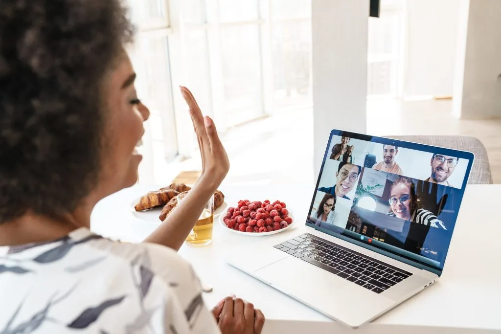 Cheerful beautiful woman using laptop to join Romanian Language Group Classes
